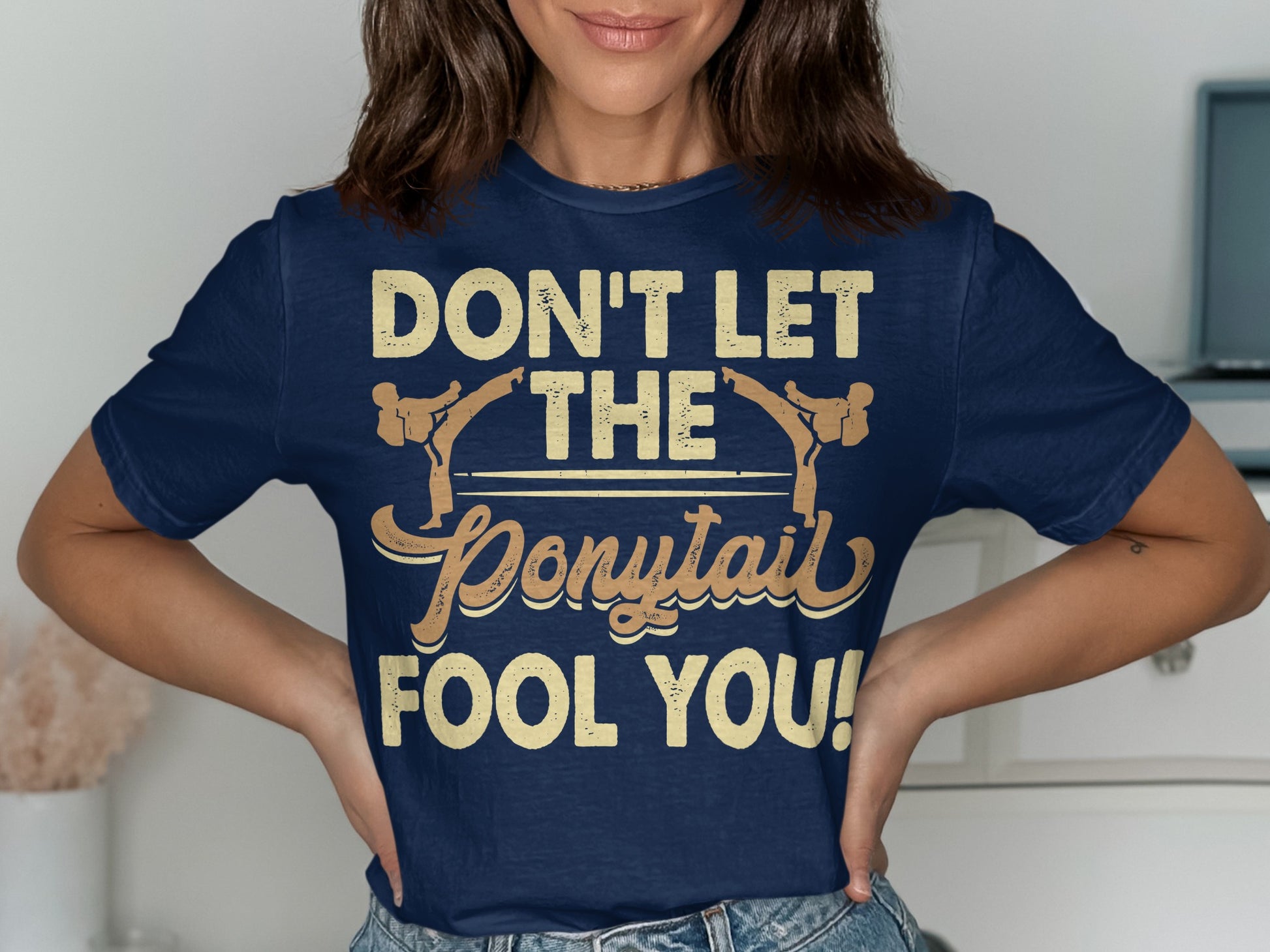 Navy t-shirt with "Don't Let The Ponytail Fool You!" text.