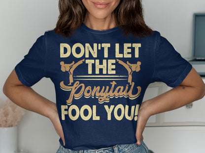 Navy t-shirt with "Don't Let The Ponytail Fool You!" text.