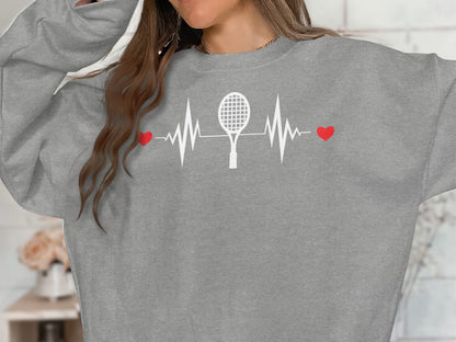 Grey sweatshirt with a white heartbeat graphic featuring a tennis racket and two red hearts.