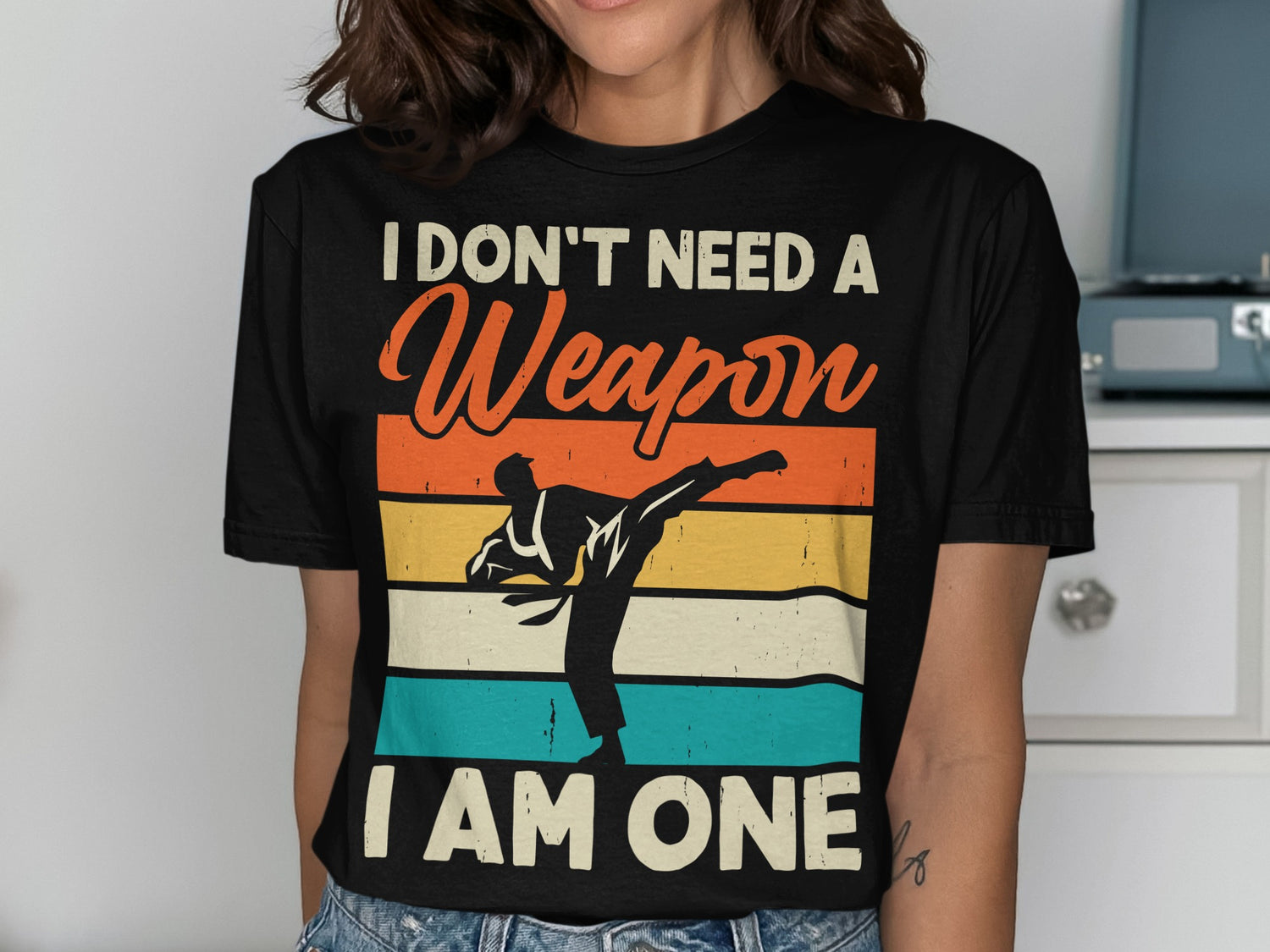 Black t-shirt with orange, yellow, and blue stripes, featuring a karate silhouette and text.