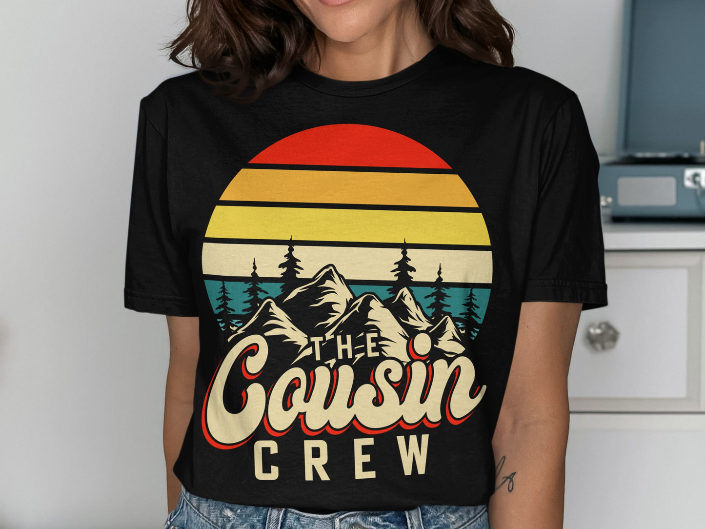 Black t-shirt with a vintage sunset, mountains, and "The Cousin Crew" text.