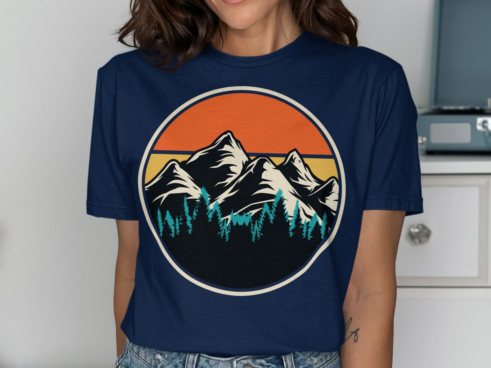 Graphic t-shirt with vintage mountain and tree landscape within a circle.