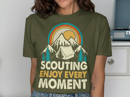 Olive green t-shirt with mountains, tent, sun, and "Scouting Enjoy Every Moment" text.
