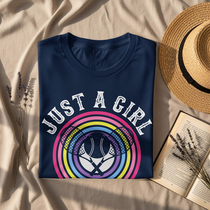 Navy t-shirt with "JUST A GIRL" text and colorful tennis rackets graphic.