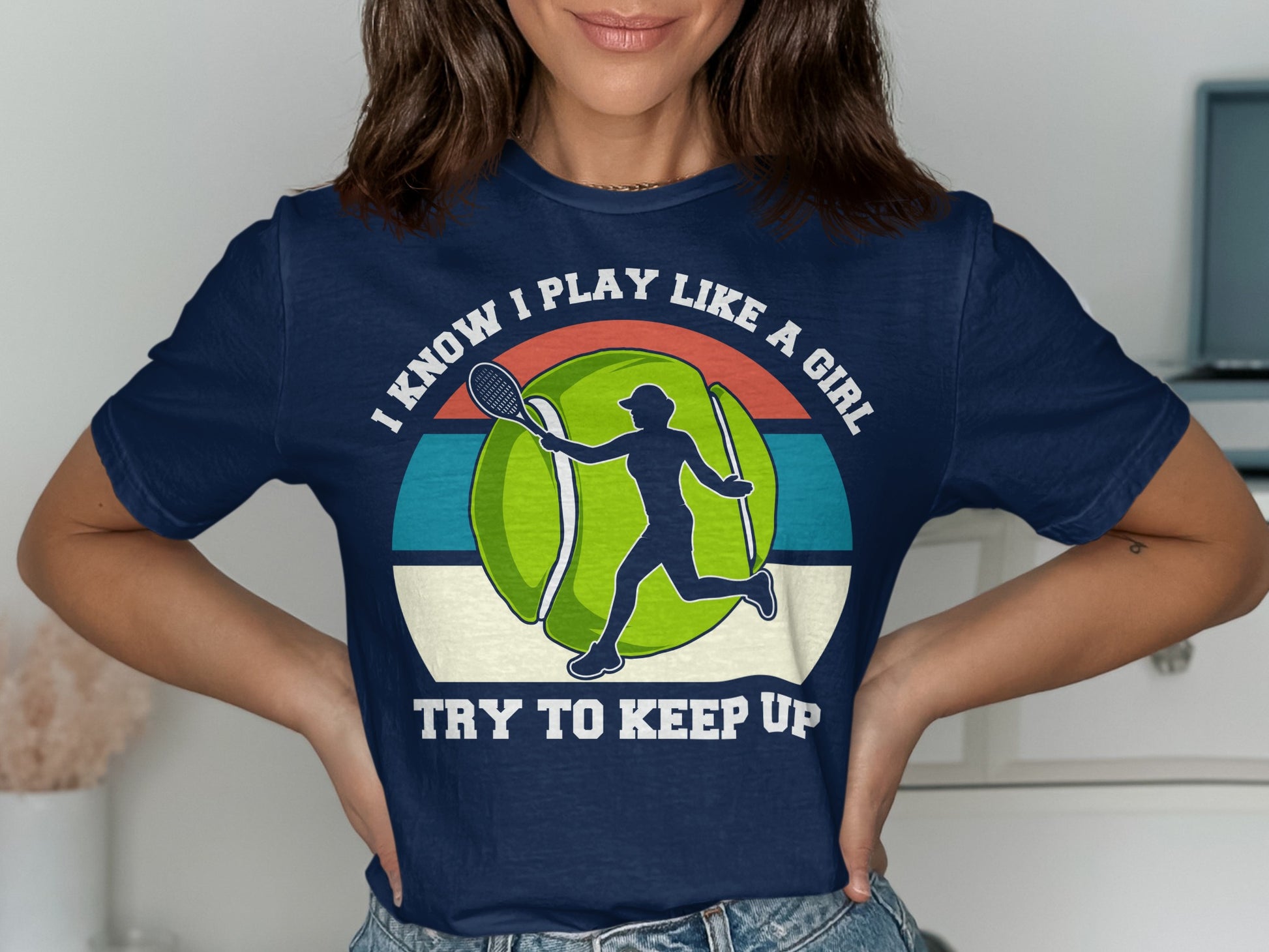 Navy t-shirt with a tennis ball graphic and text "I KNOW I PLAY LIKE A GIRL TRY TO KEEP UP".