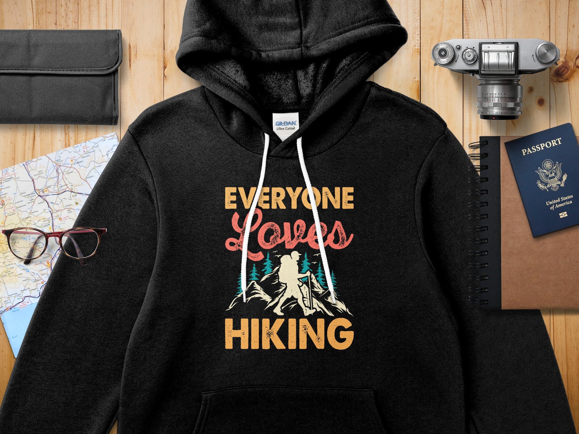 Black Gildan hoodie with "Everyone Loves Hiking" text and mountain graphic.