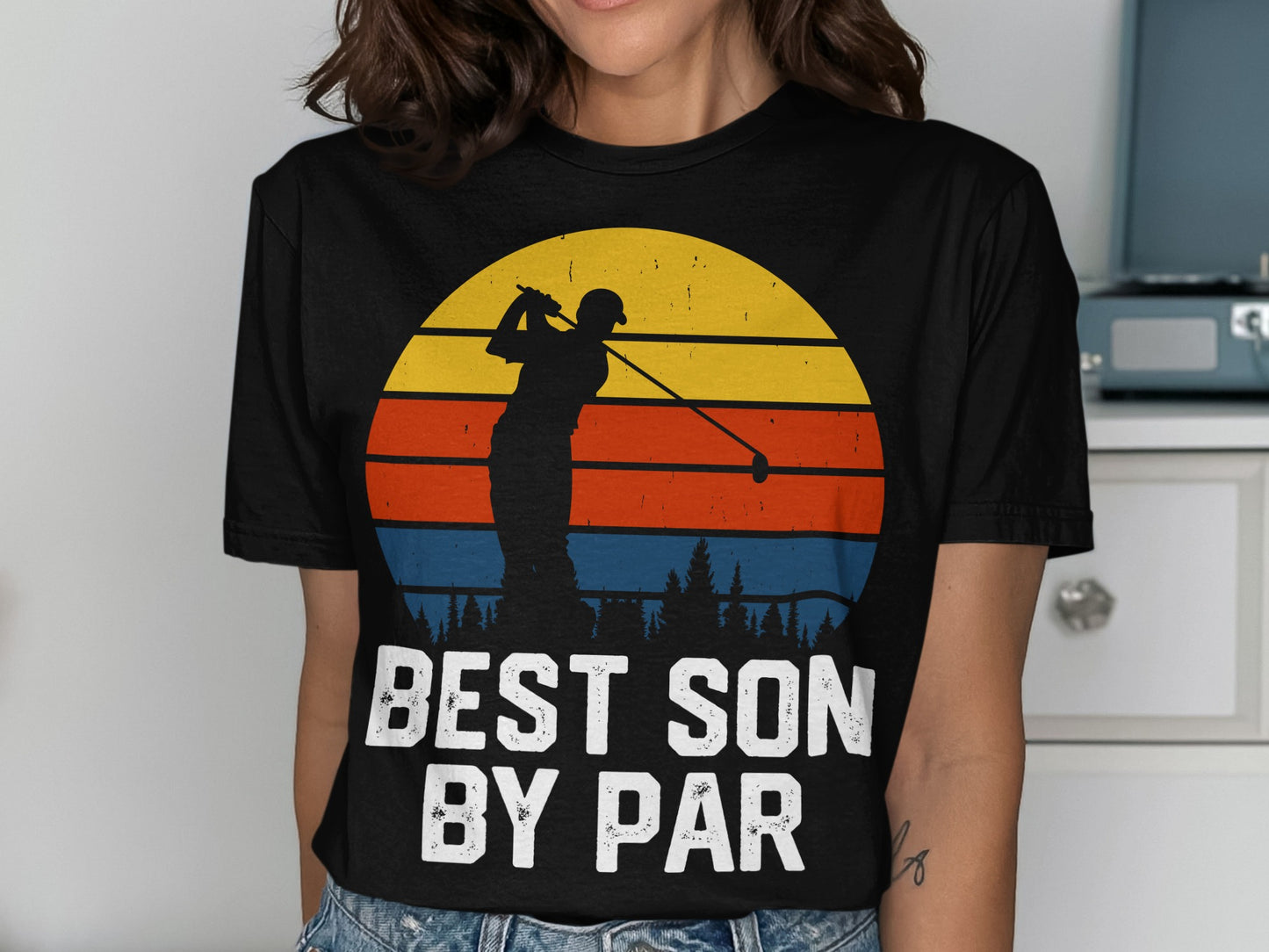Black t-shirt with golfer silhouette against a sunset and text "BEST SON BY PAR".