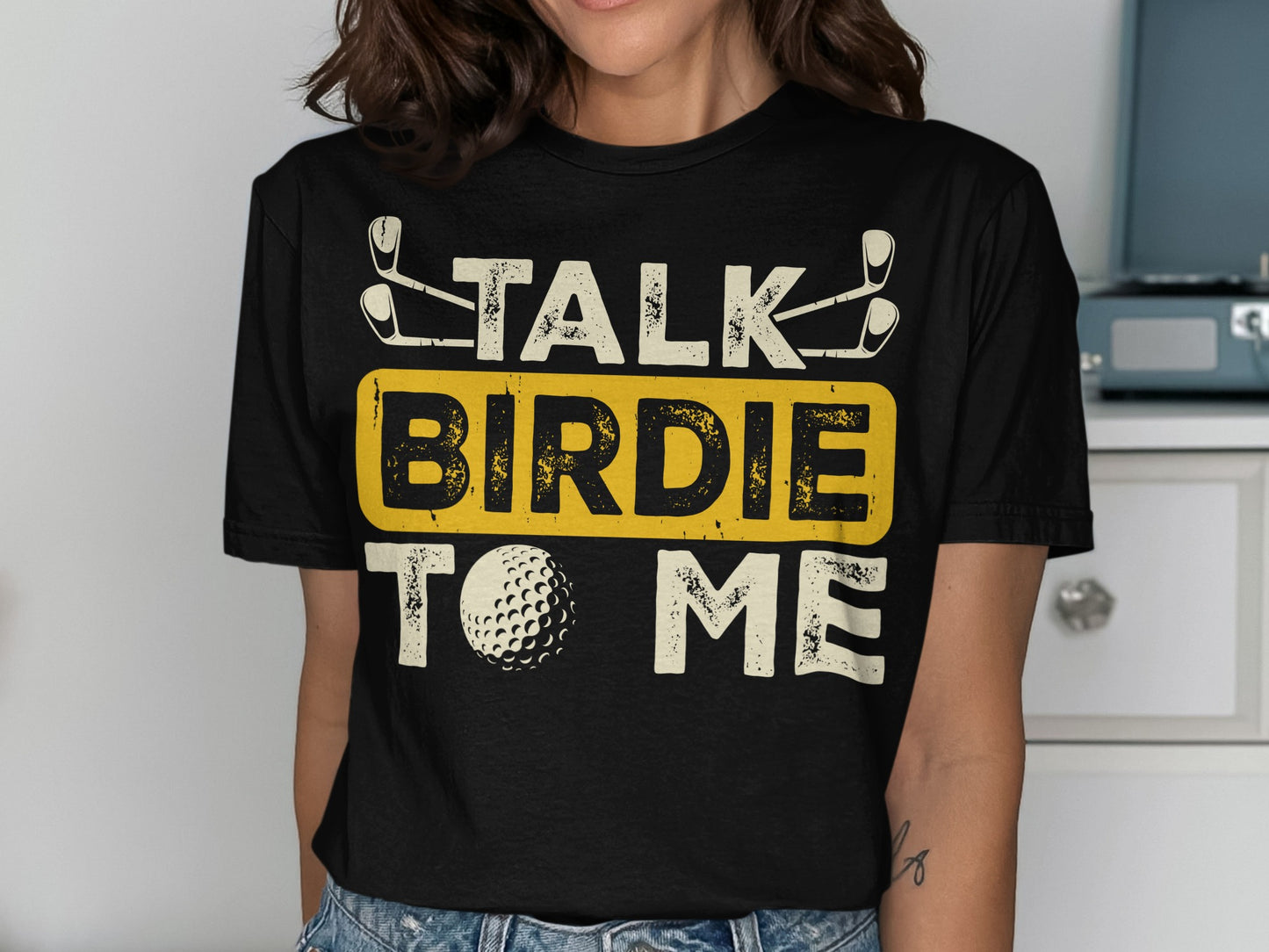 Black t-shirt with "TALK BIRDIE TO ME" and golf ball graphic.
