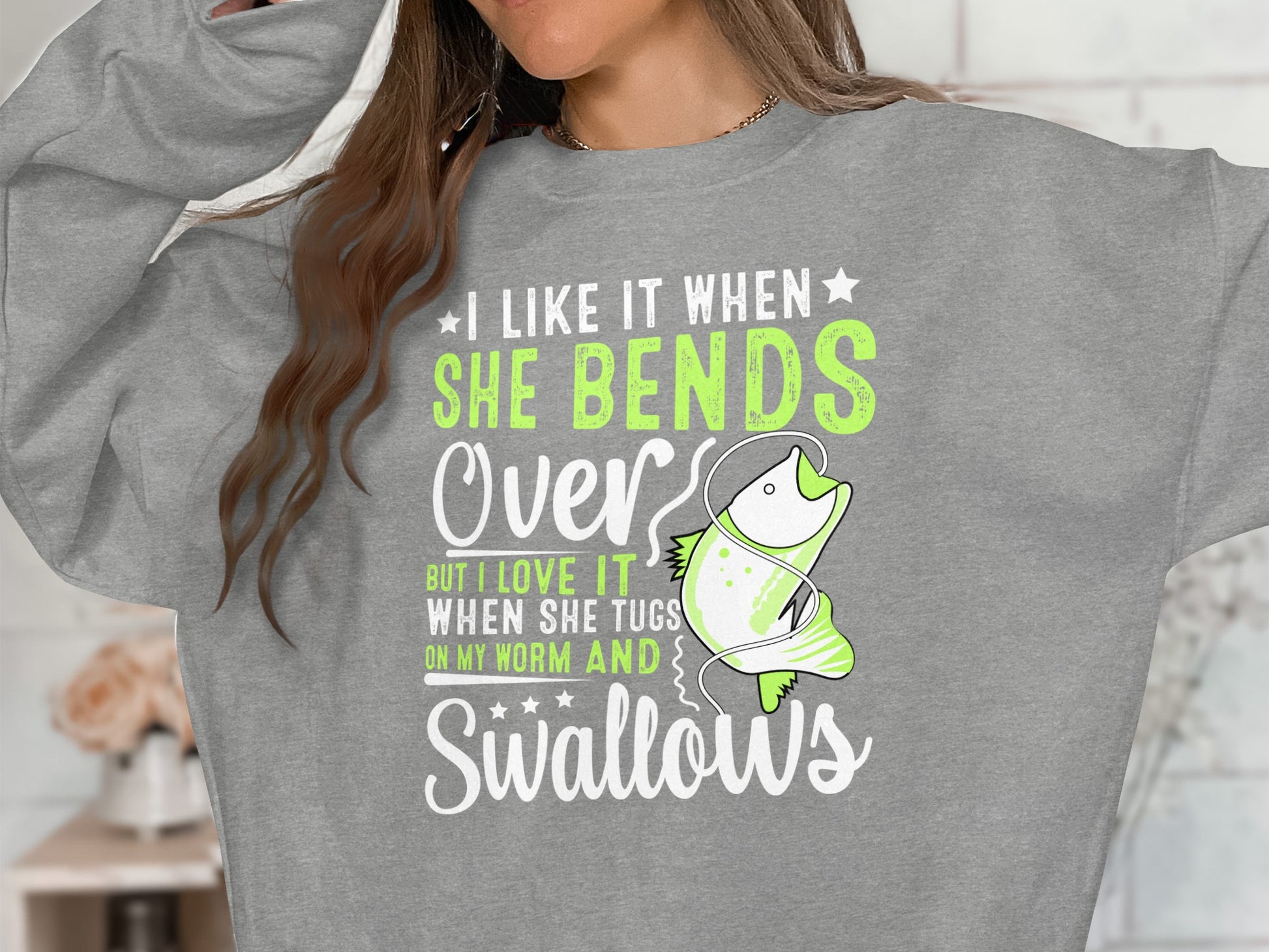 Gray sweatshirt with green text and a cartoon fish saying "I like it when she bends over".
