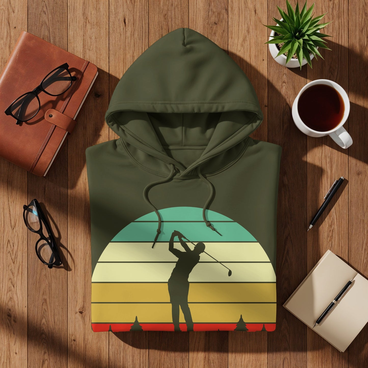 Olive green hoodie with a golfer silhouette against a retro sunset graphic.