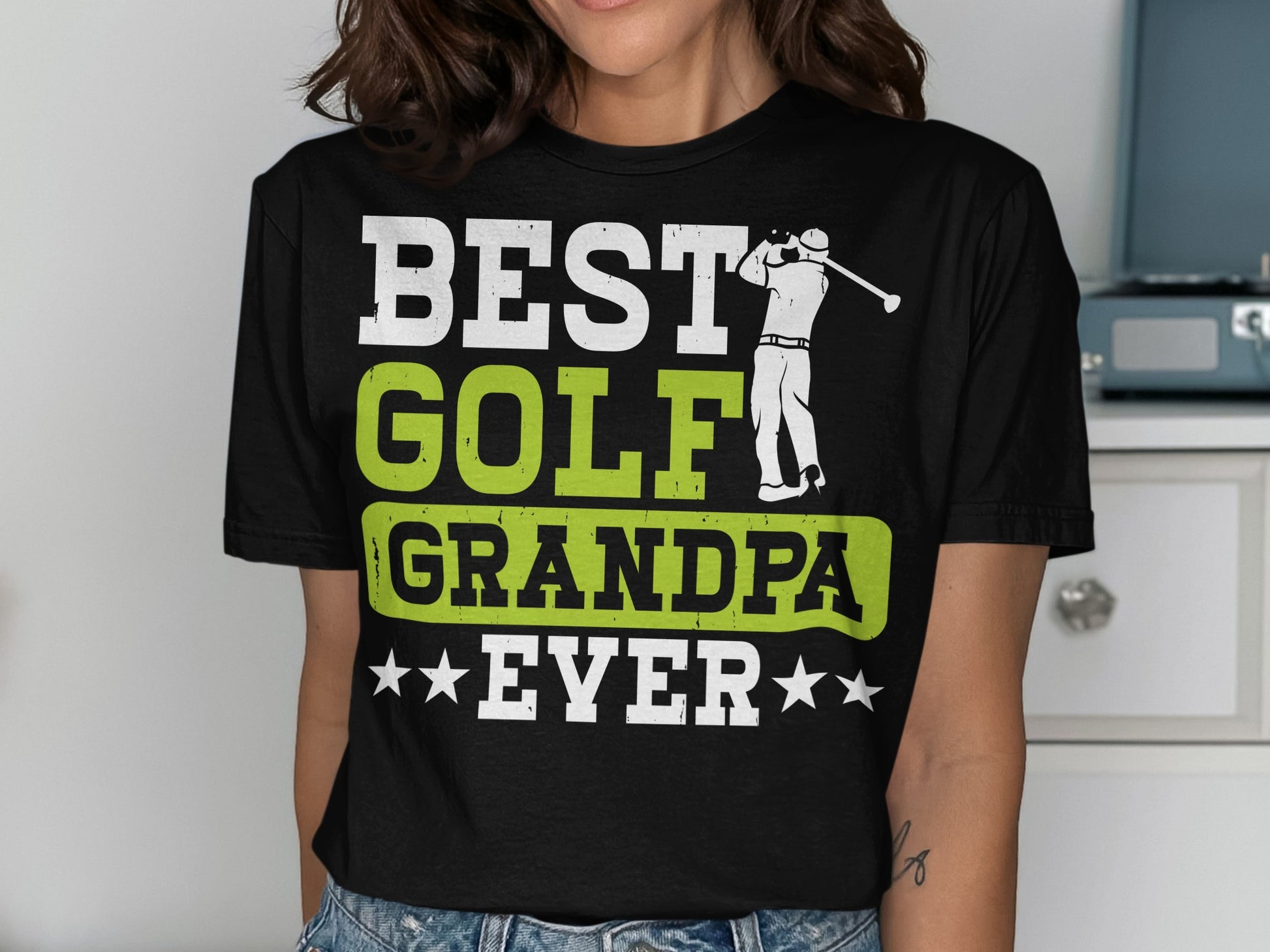 Black t-shirt with "BEST GOLF GRANDPA EVER" in white and green, and a golf player graphic.