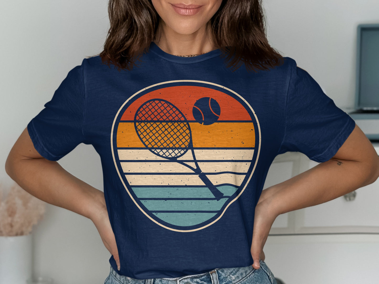 Navy t-shirt with retro tennis racket, ball, and sunset graphic.