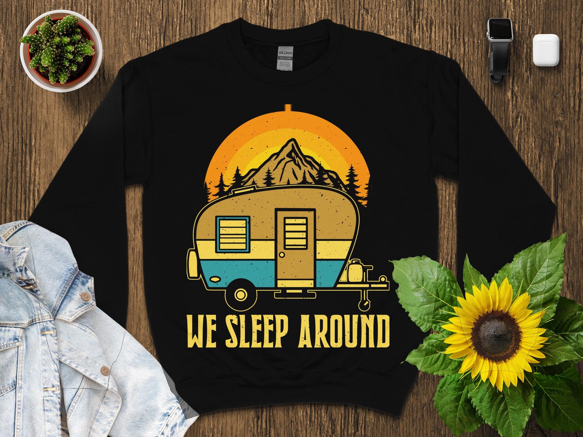 Camper van with sunset and mountains, "We Sleep Around" text.