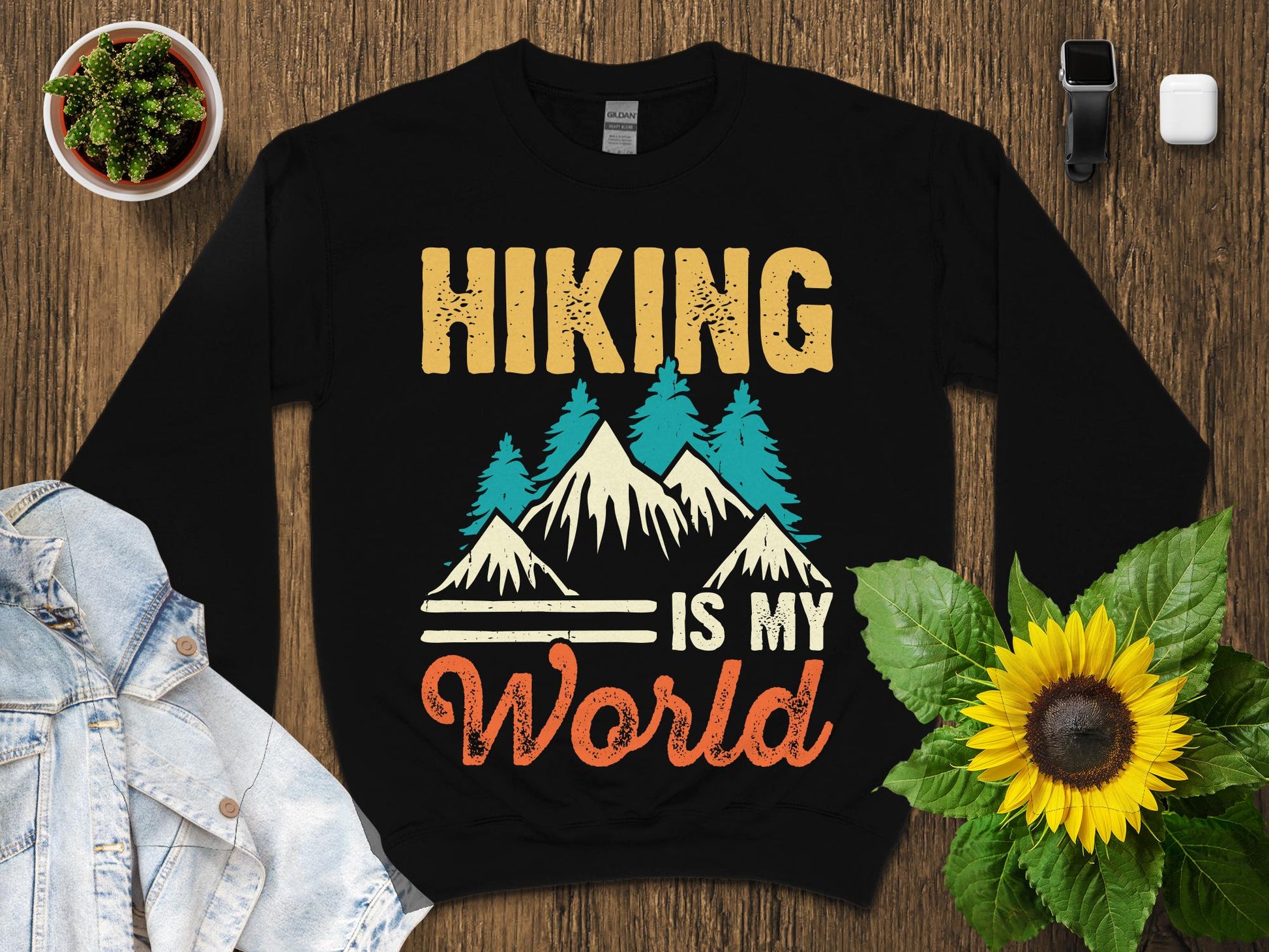 Black sweatshirt with "Hiking is my World" text and mountain graphic.