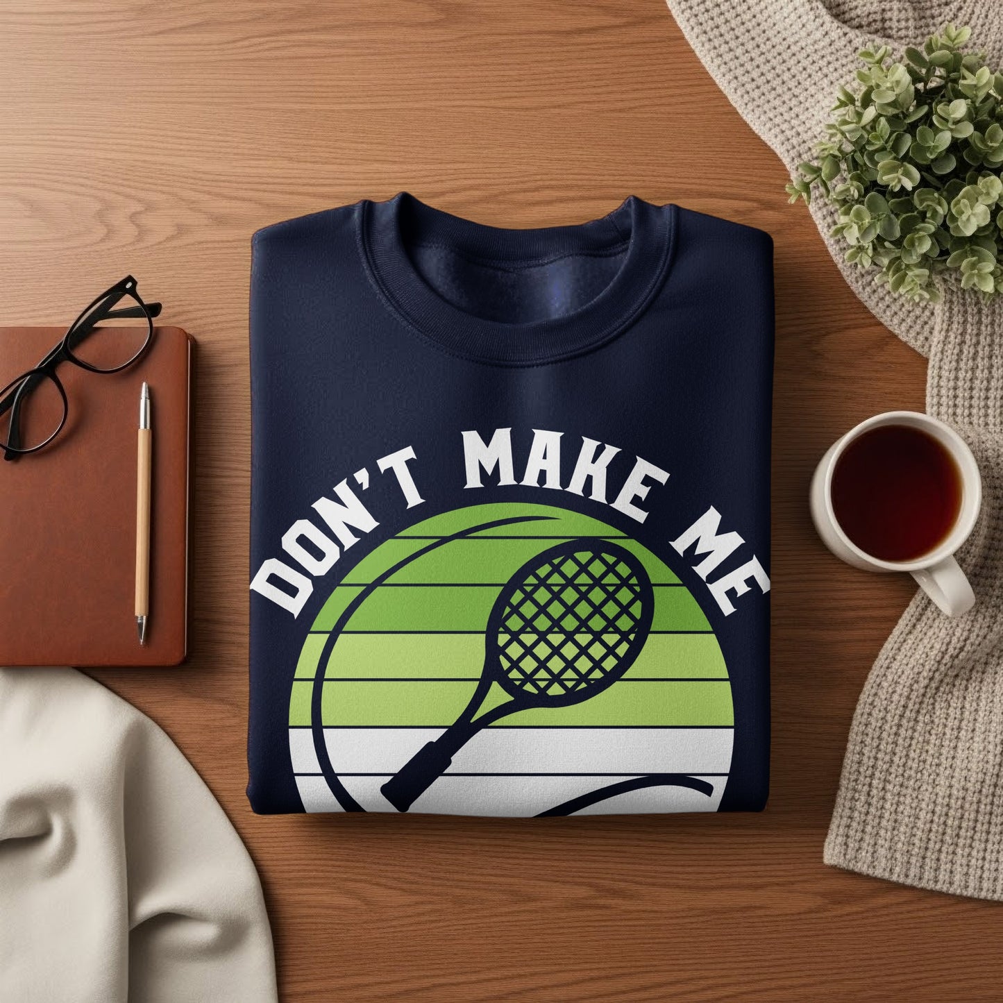 Navy sweatshirt with "Don't Make Me" text and tennis racket graphic.
