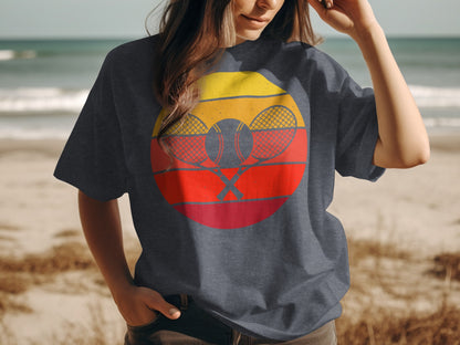Dark grey t-shirt with crossed tennis rackets and ball in a sunset graphic.