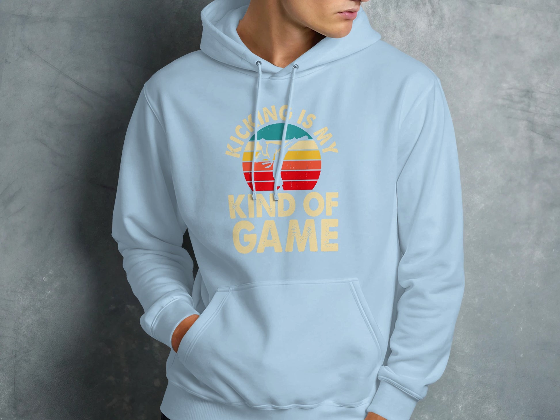 Light blue hoodie with "KICKING IS MY GAME" text and sunset graphic.