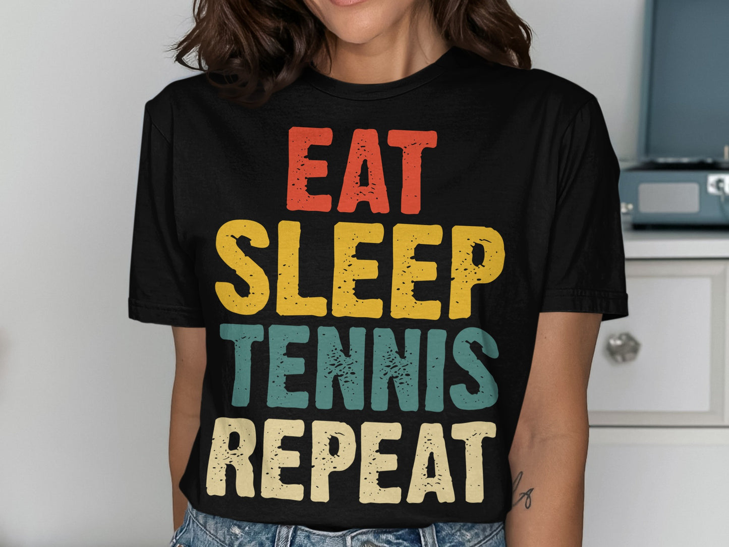 Black t-shirt with "Eat Sleep Tennis Repeat" in colorful retro text.