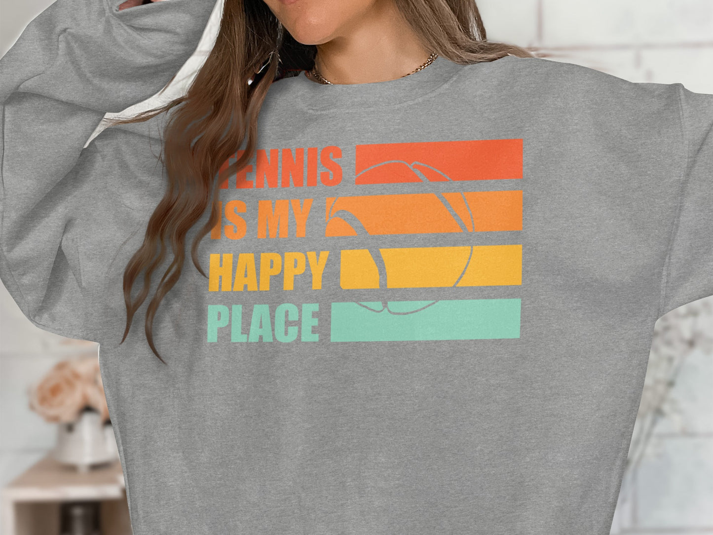 Gray sweatshirt with "Tennis is my happy place" graphic and tennis ball illustration.