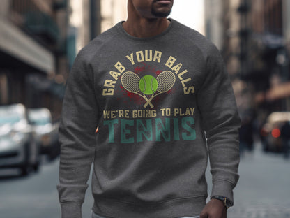 Grey sweatshirt with "Grab Your Balls We're Going to Play Tennis" text and tennis balls graphic.
