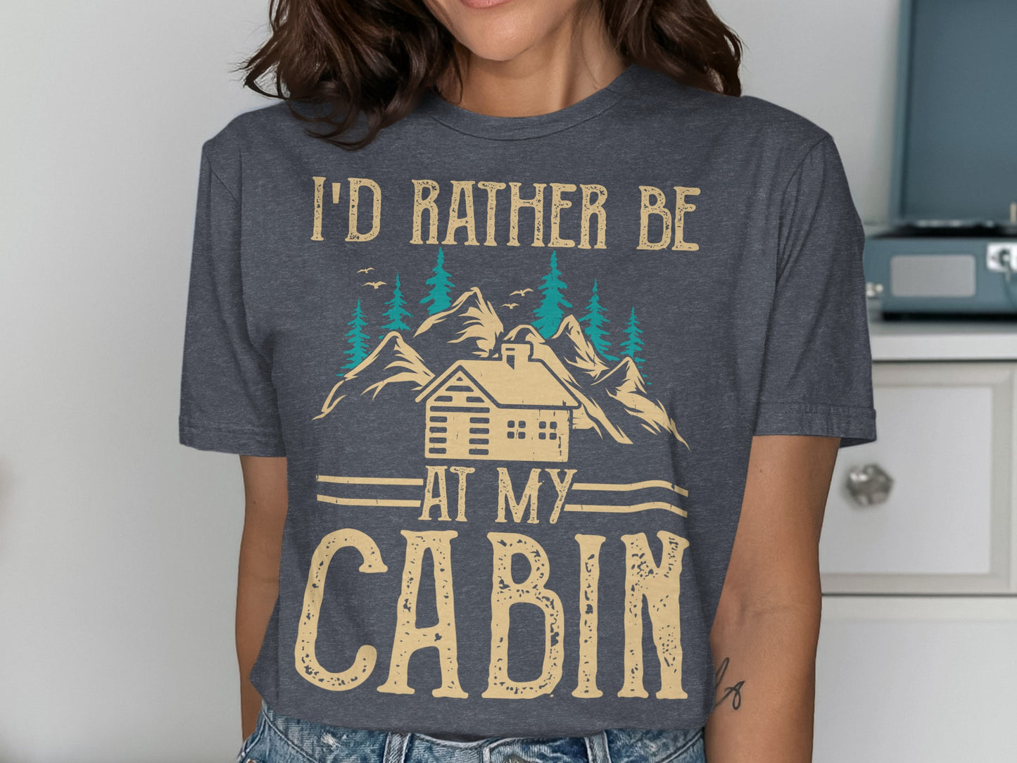 T-shirt with "I'd rather be at my cabin" text and cabin illustration.