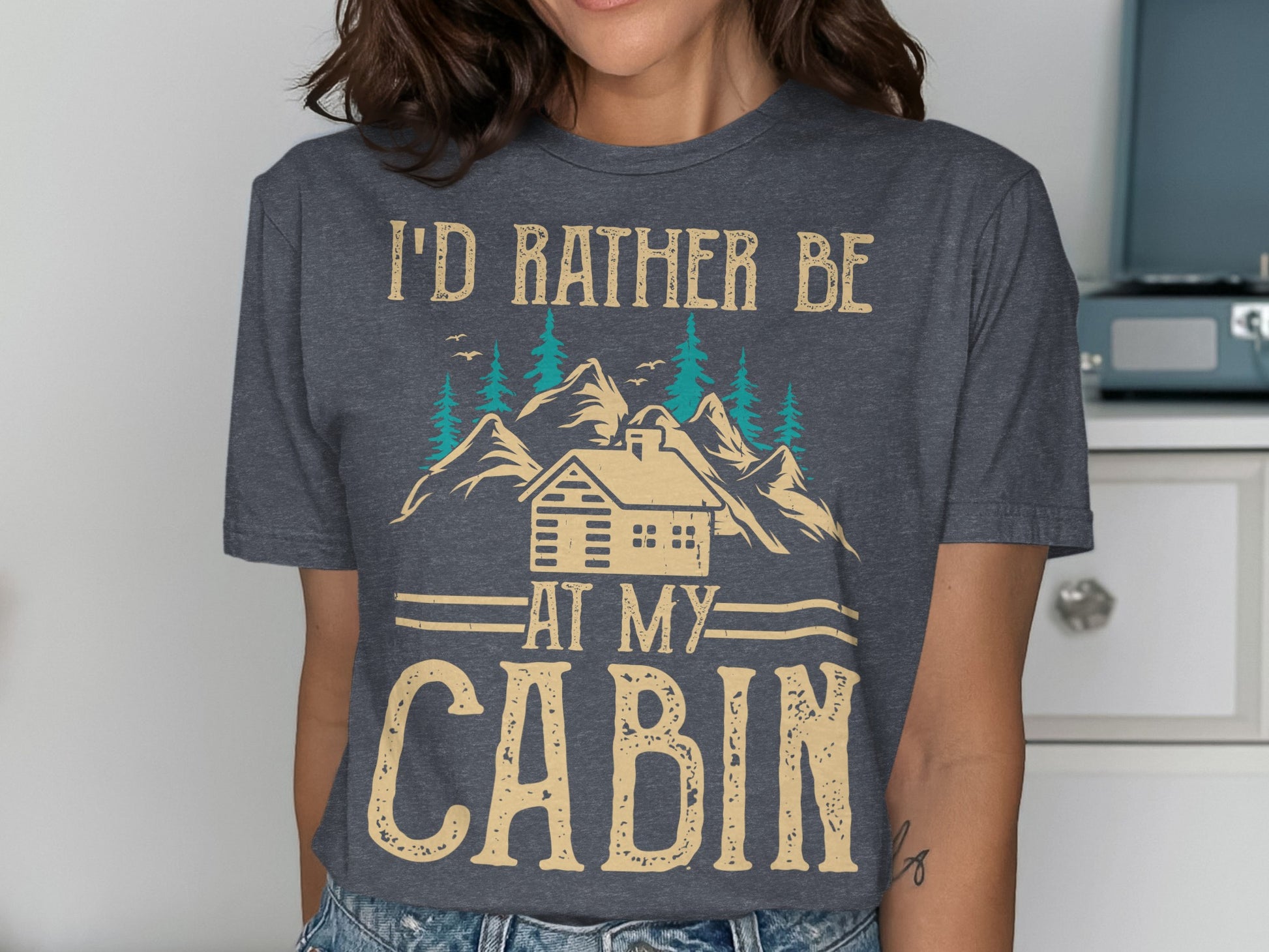 T-shirt with "I'd rather be at my cabin" text and cabin illustration.