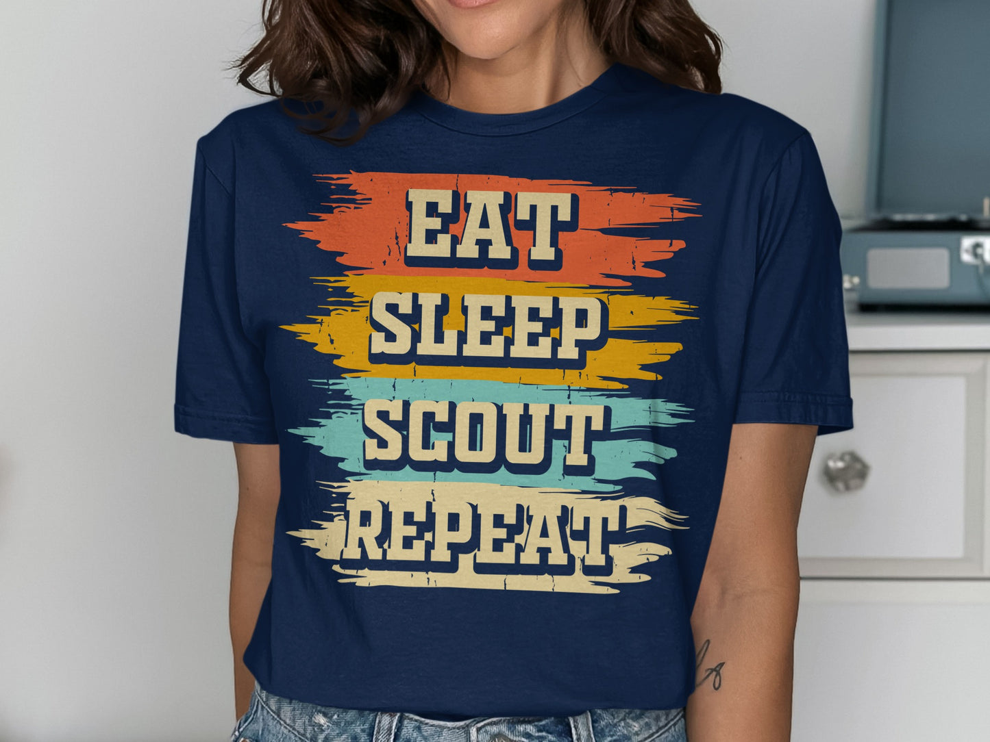 Navy t-shirt with "Eat Sleep Scout Repeat" text in distressed colorful stripes.