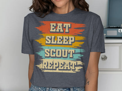 Dark grey t-shirt with "Eat Sleep Scout Repeat" in distressed colorful text.