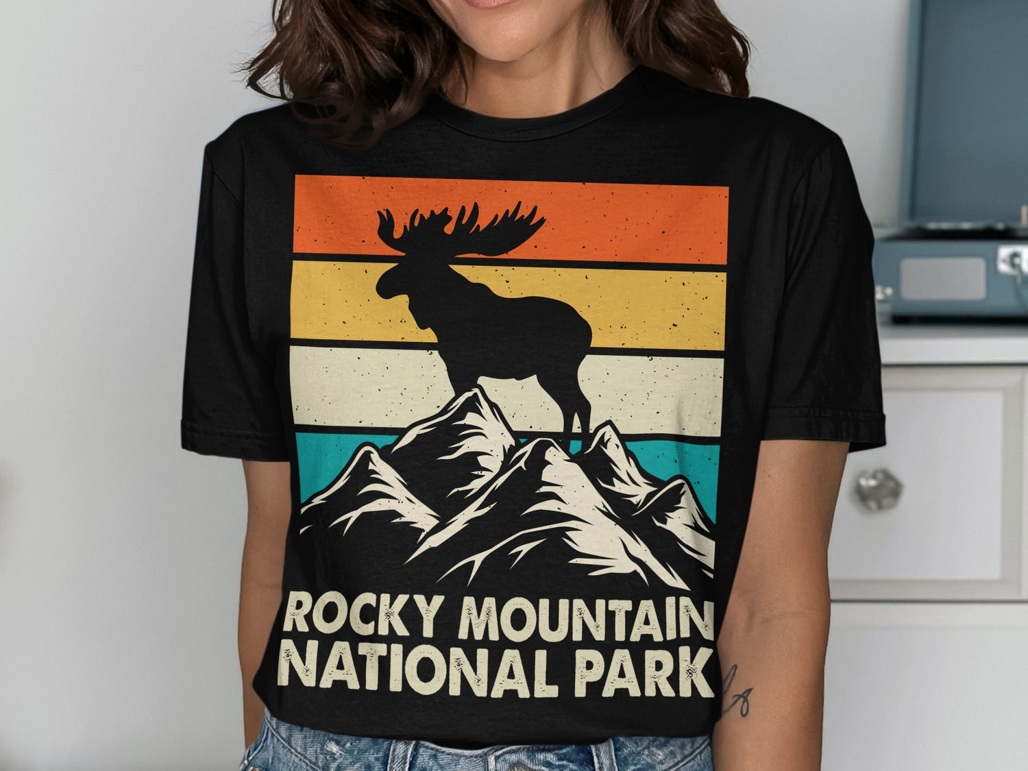 Silhouette of a moose on a mountain peak with "Rocky Mountain National Park" text.