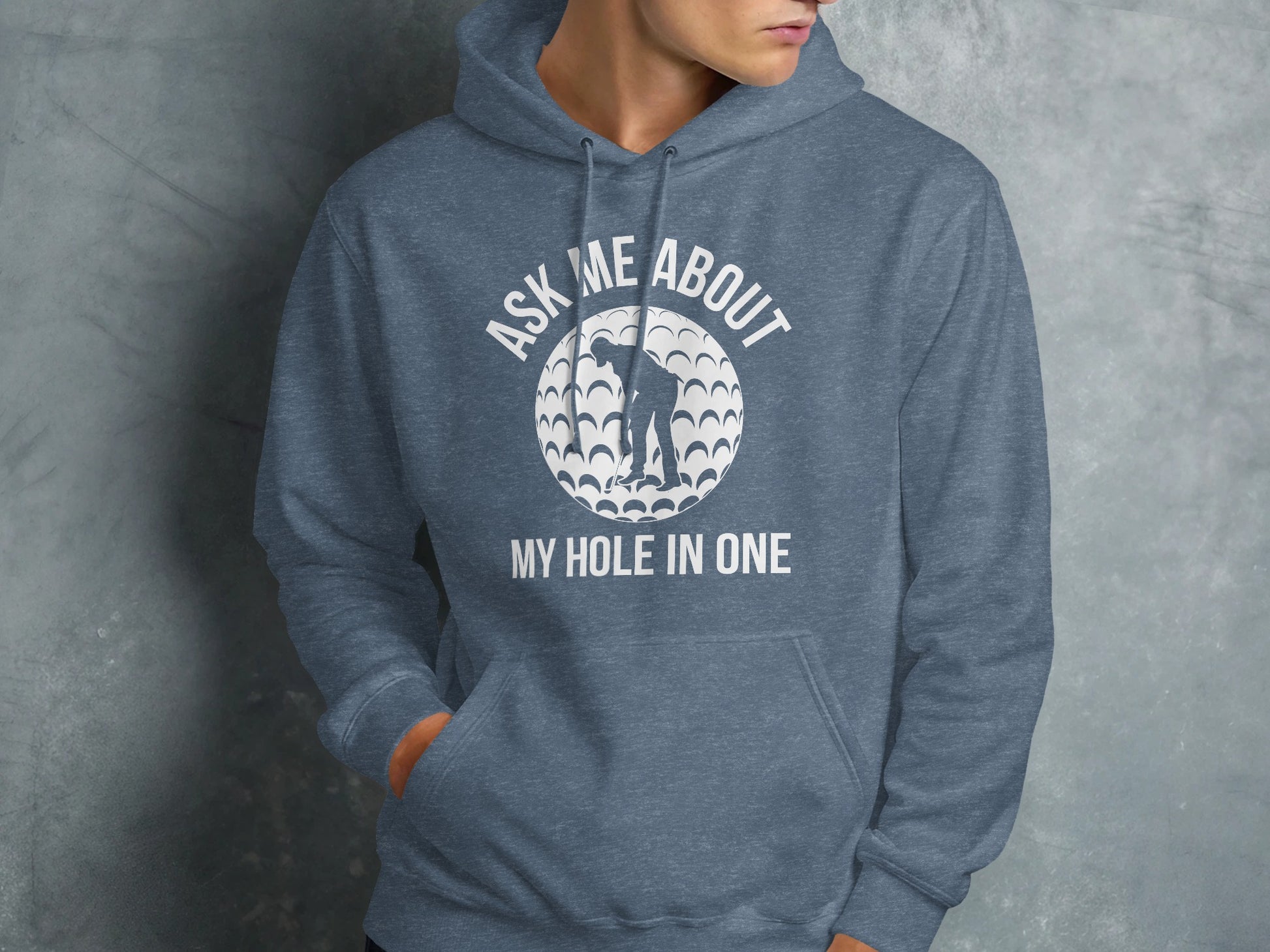 Blue hoodie with white text "ASK ME ABOUT MY HOLE IN ONE" and a golf ball graphic.