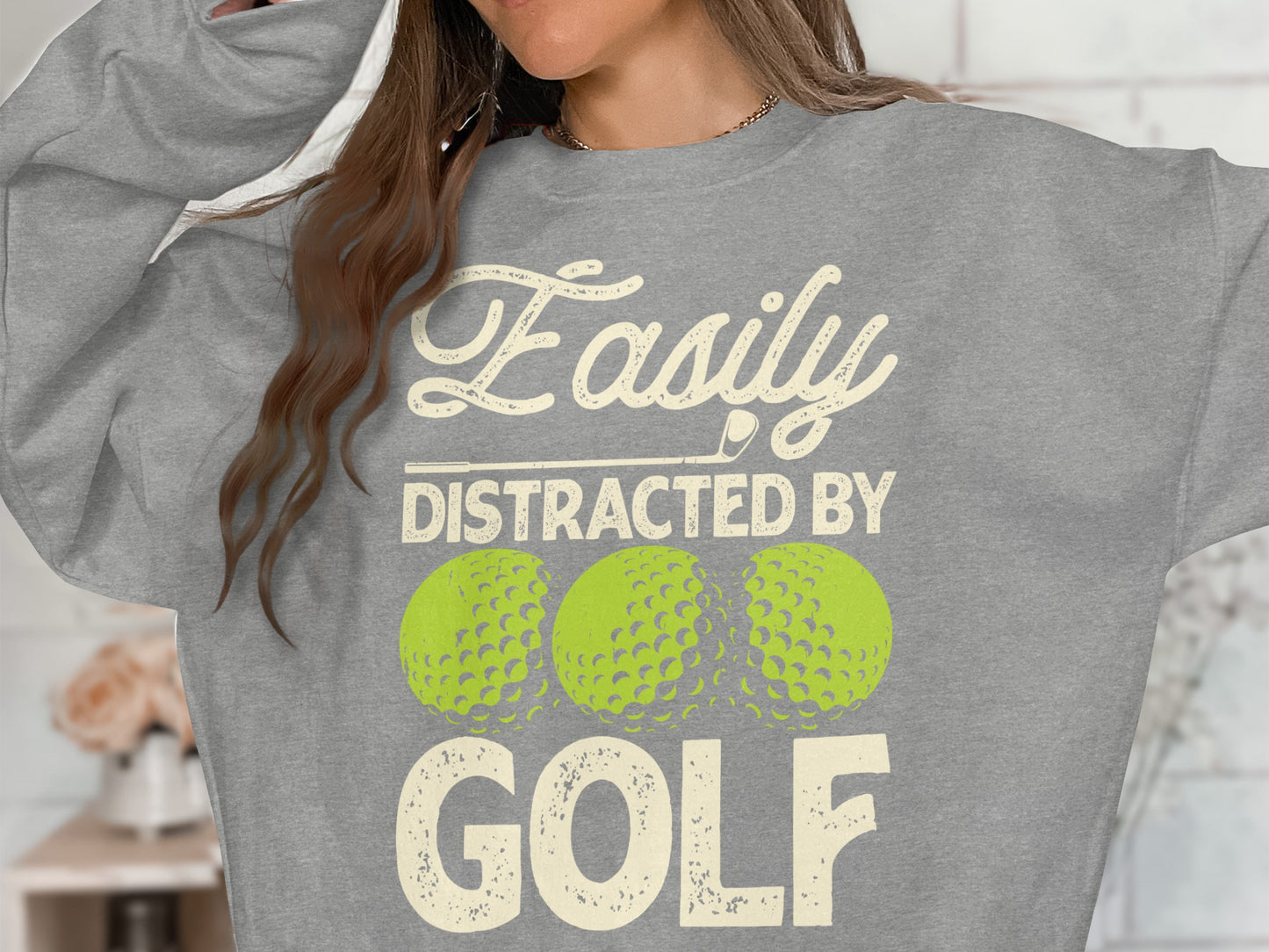 Gray sweatshirt with "Easily Distracted By GOLF" text and golf balls.