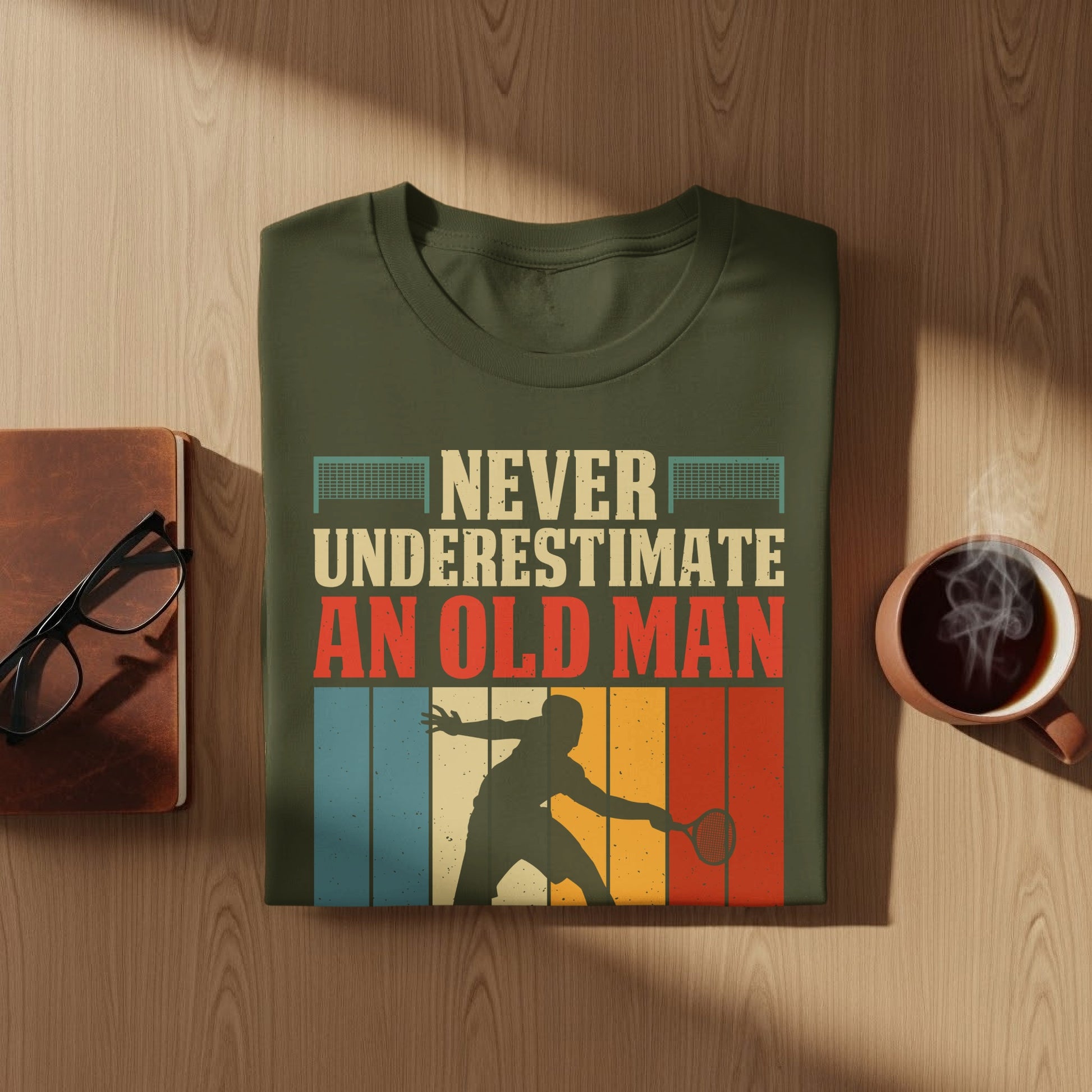 Olive green t-shirt with "Never Underestimate An Old Man" text and tennis player graphic.