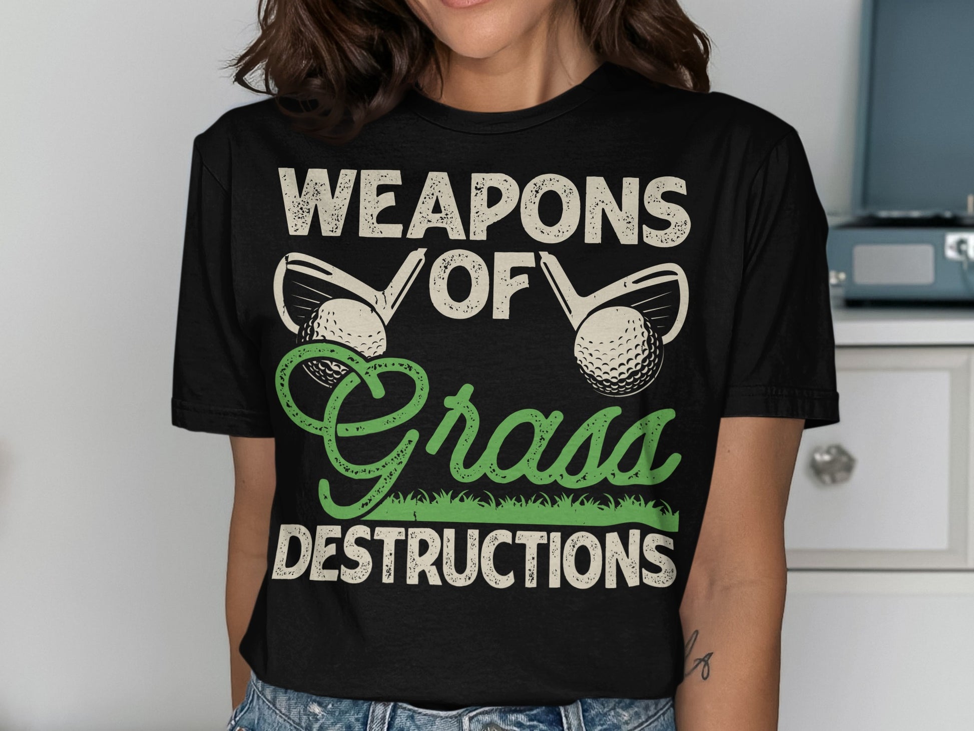 T-shirt with "WEAPONS OF Grass DESTRUCTIONS" text and golf club graphics.