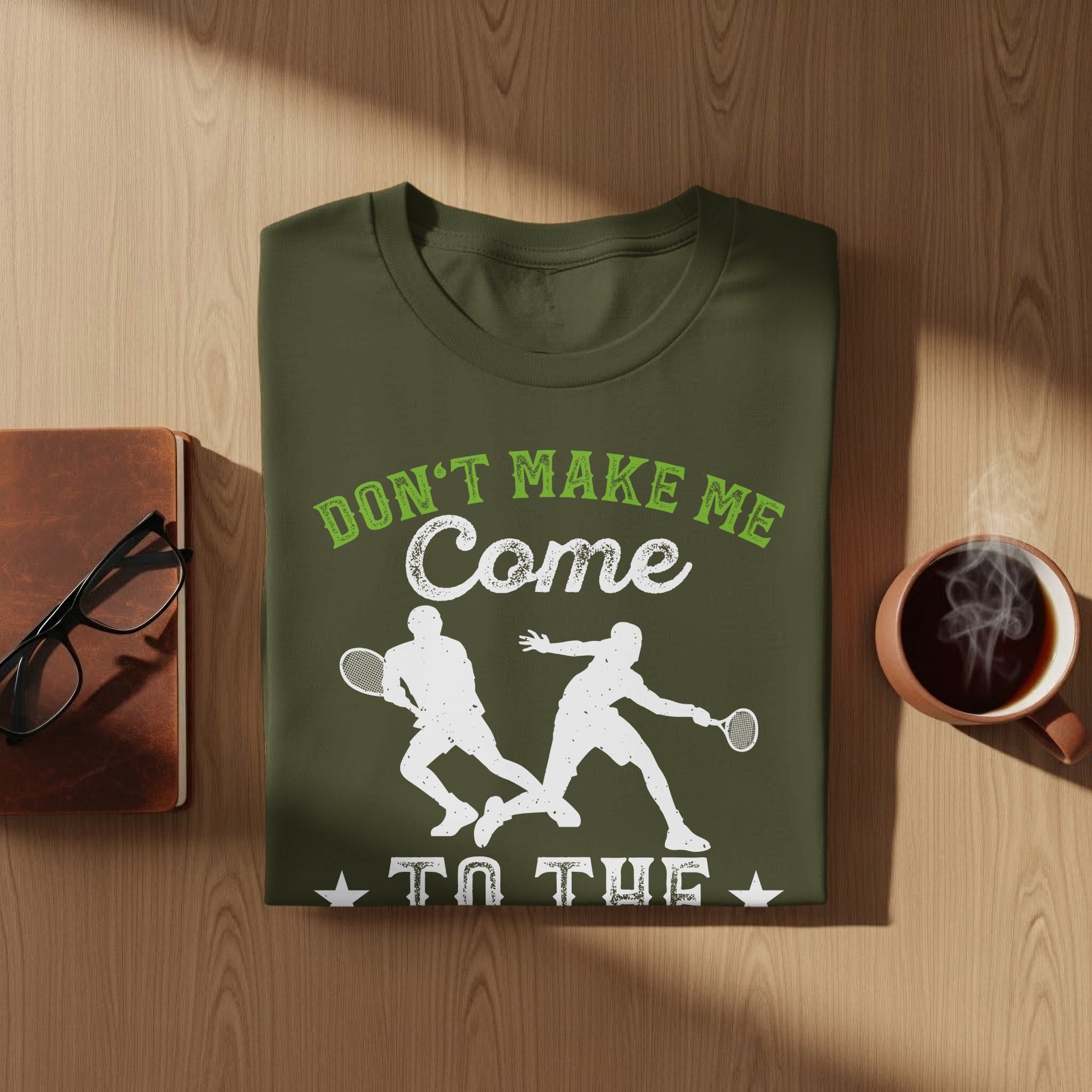Green t-shirt with white graphic of two tennis players and text "Don't Make Me Come To The".