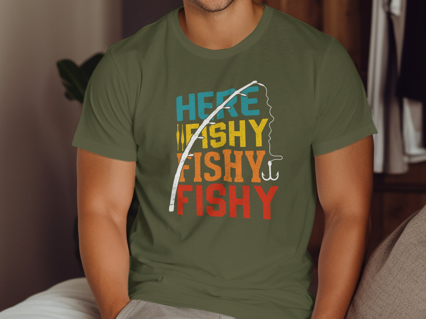 Olive green t-shirt with "HERE WE GO FISHY FISHY FISHY" text and fishing hook.