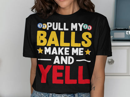 Black t-shirt with "PULL MY BALLS MAKE ME AND YELL" text in yellow and red.