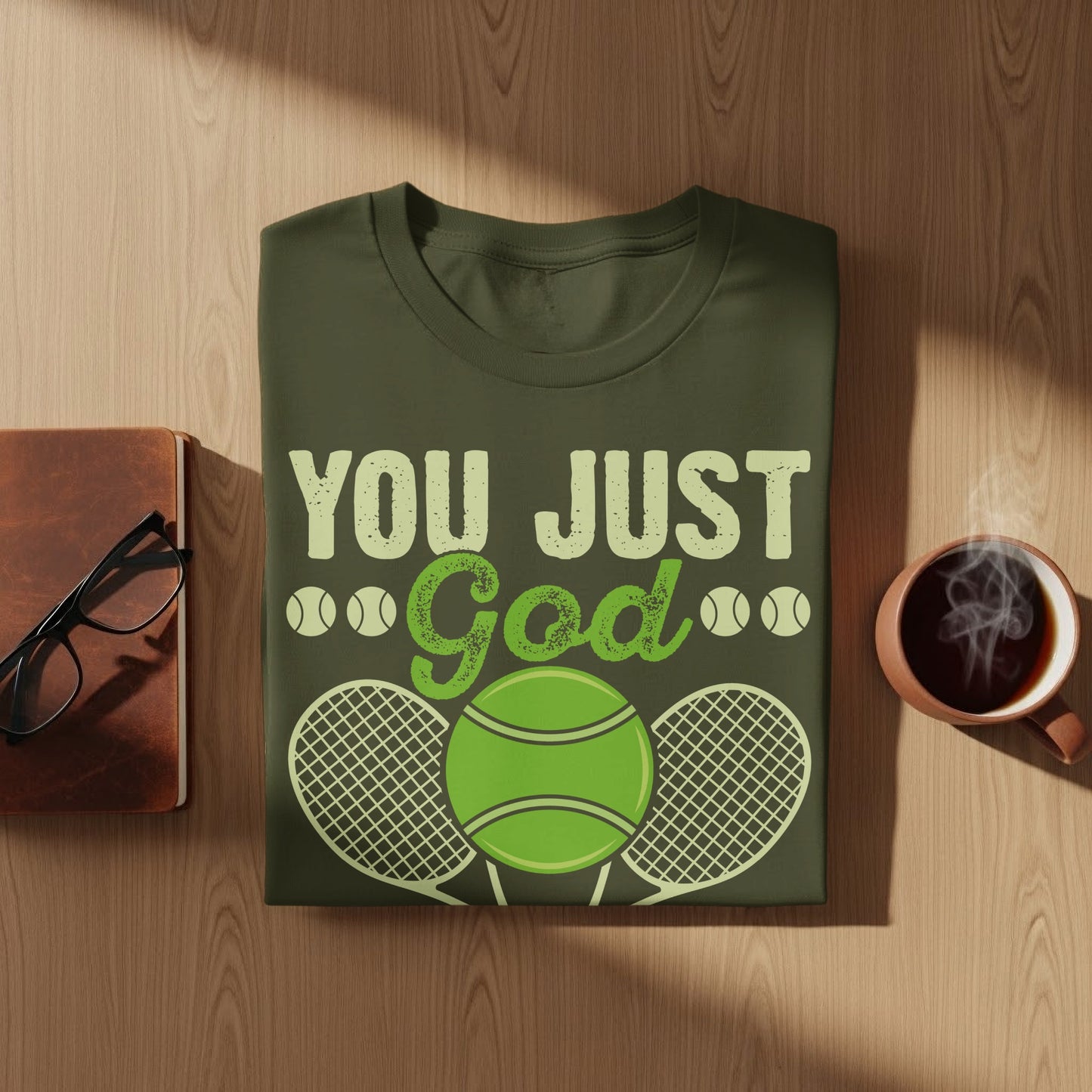 Green t-shirt with "You Just God" text and tennis ball graphic.