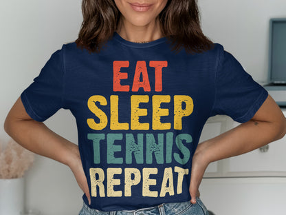 Navy t-shirt with "EAT SLEEP TENNIS REPEAT" text in colorful block letters.