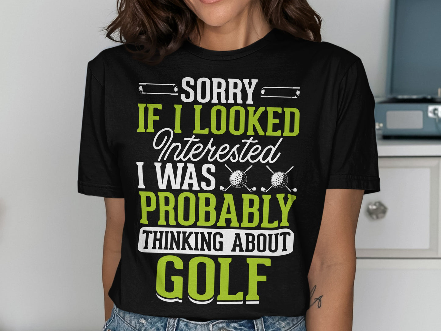 Black t-shirt with "SORRY IF I LOOKED INTERESTED I WAS PROBABLY THINKING ABOUT GOLF" text.