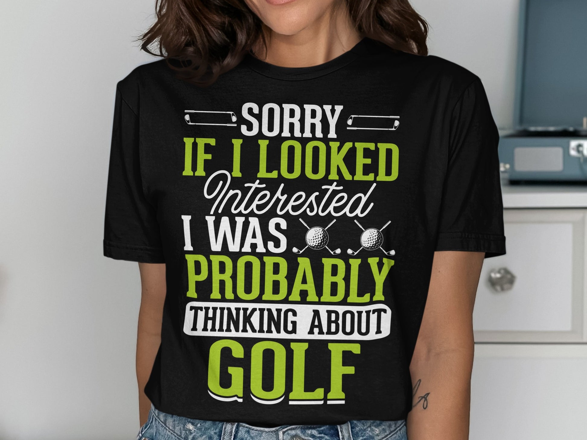 Black t-shirt with "SORRY IF I LOOKED INTERESTED I WAS PROBABLY THINKING ABOUT GOLF" text.