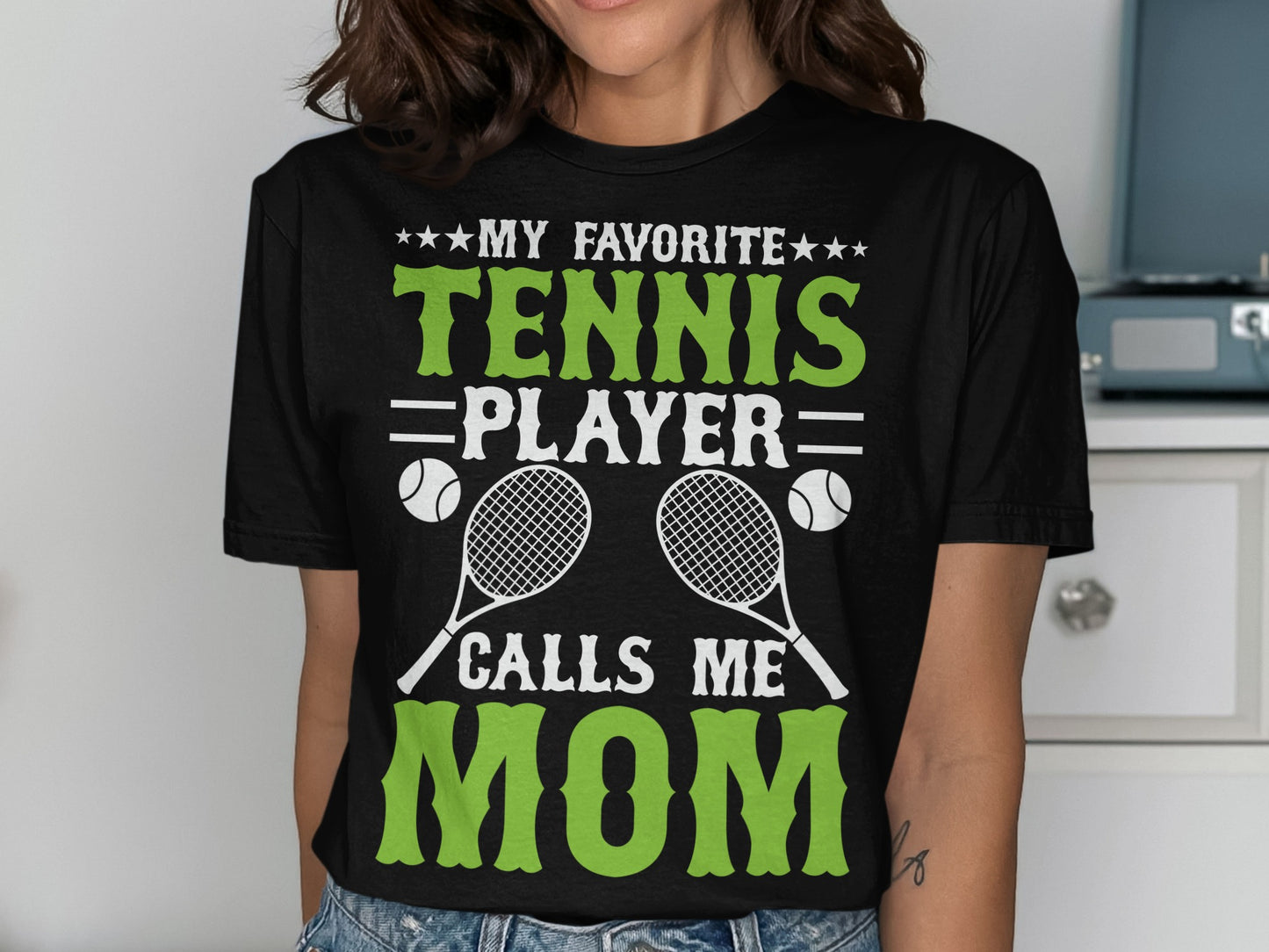Black t-shirt with "My Favorite Tennis Player Calls Me Mom" and tennis graphics.
