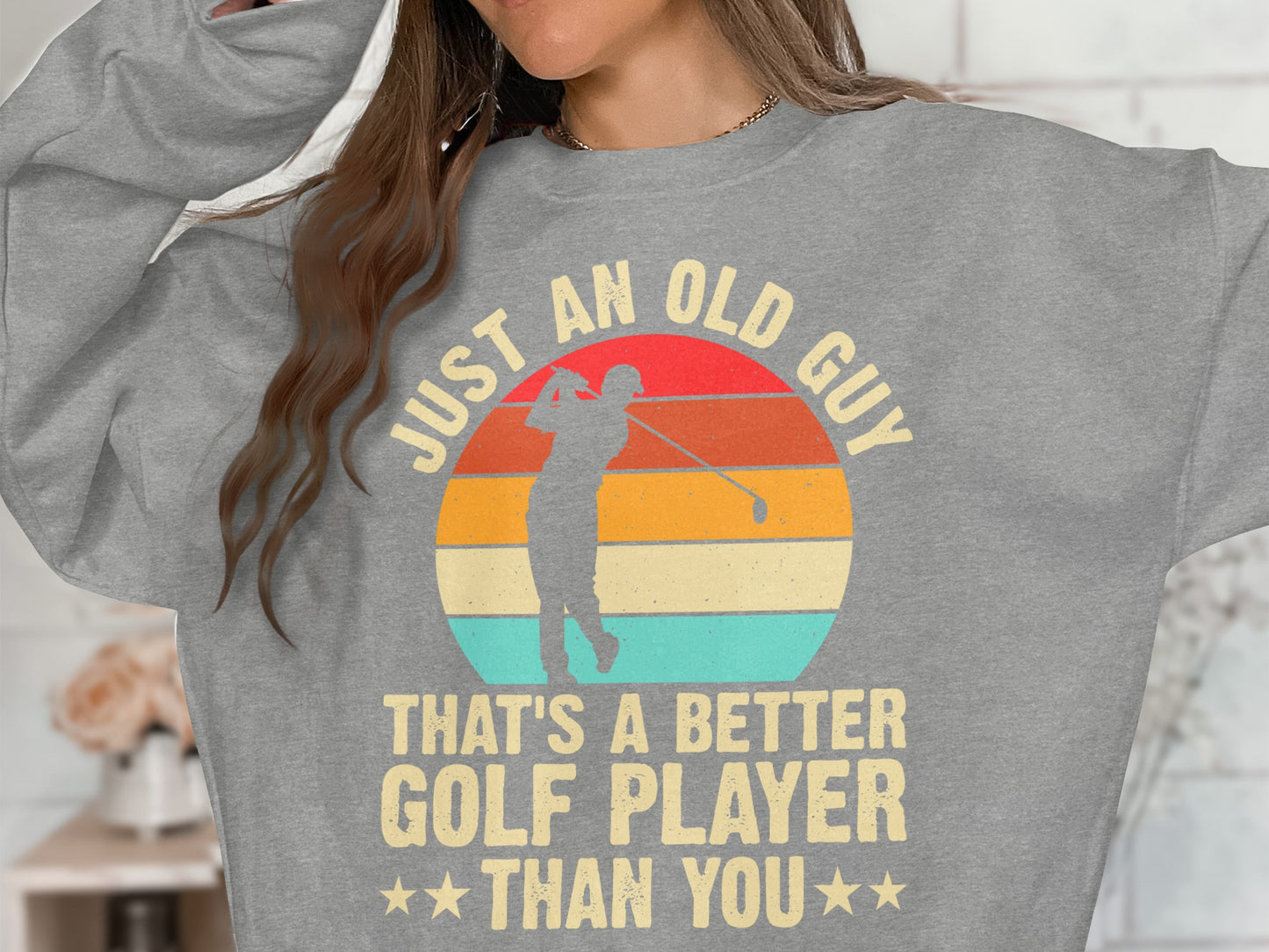 Gray sweatshirt with "JUST AN OLD GUY THAT'S A BETTER GOLF PLAYER THAN YOU" slogan.