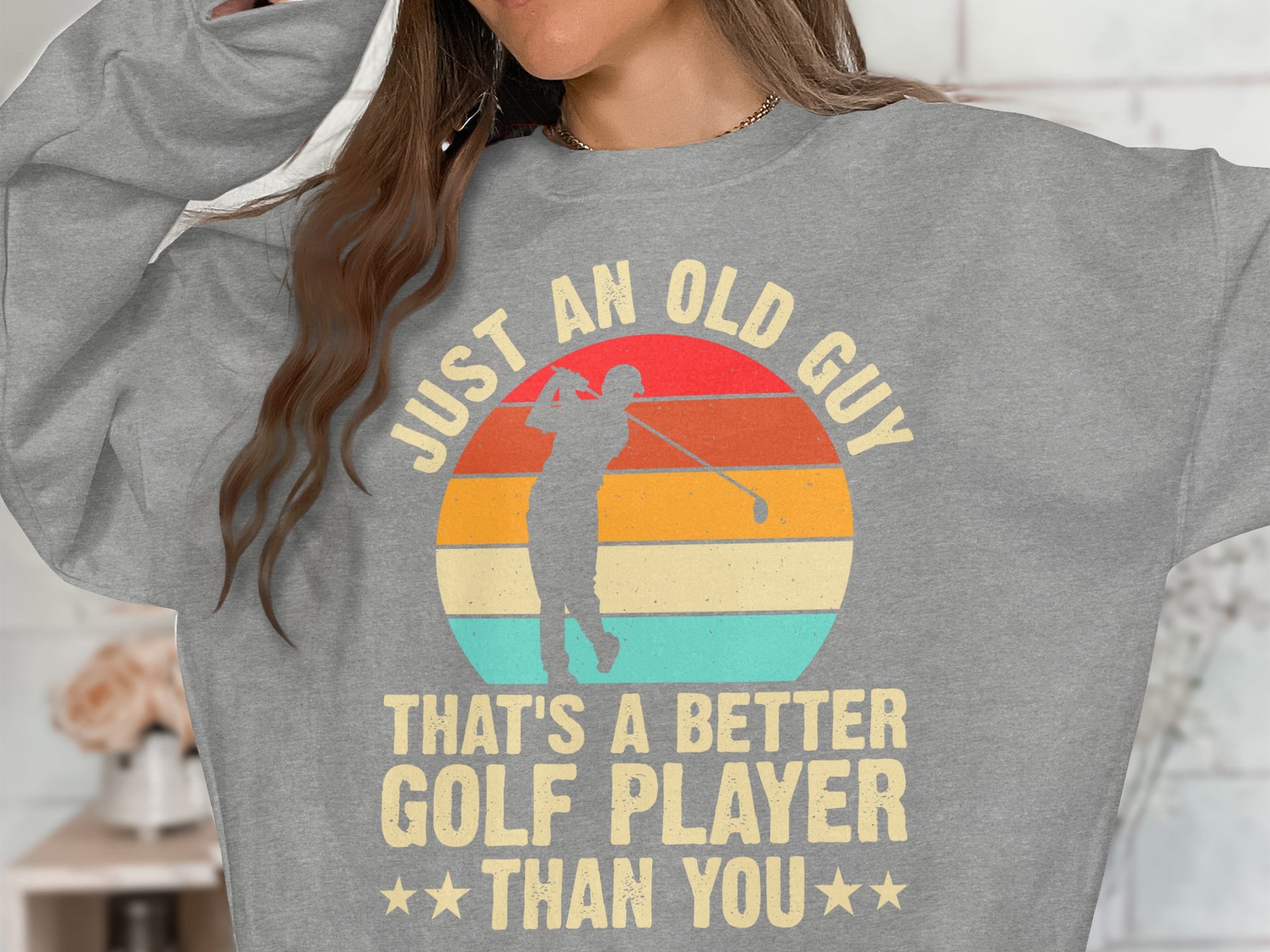 Gray sweatshirt with "JUST AN OLD GUY THAT'S A BETTER GOLF PLAYER THAN YOU" slogan.