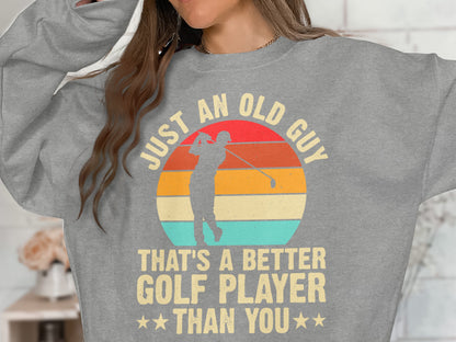 Gray sweatshirt with "JUST AN OLD GUY THAT'S A BETTER GOLF PLAYER THAN YOU" slogan.
