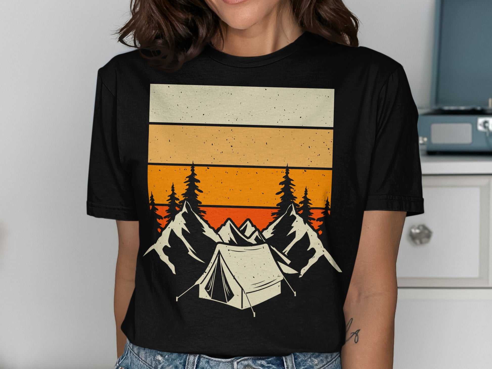 Black t-shirt with vintage camping scene graphic: tent, mountains, trees, and stripes.