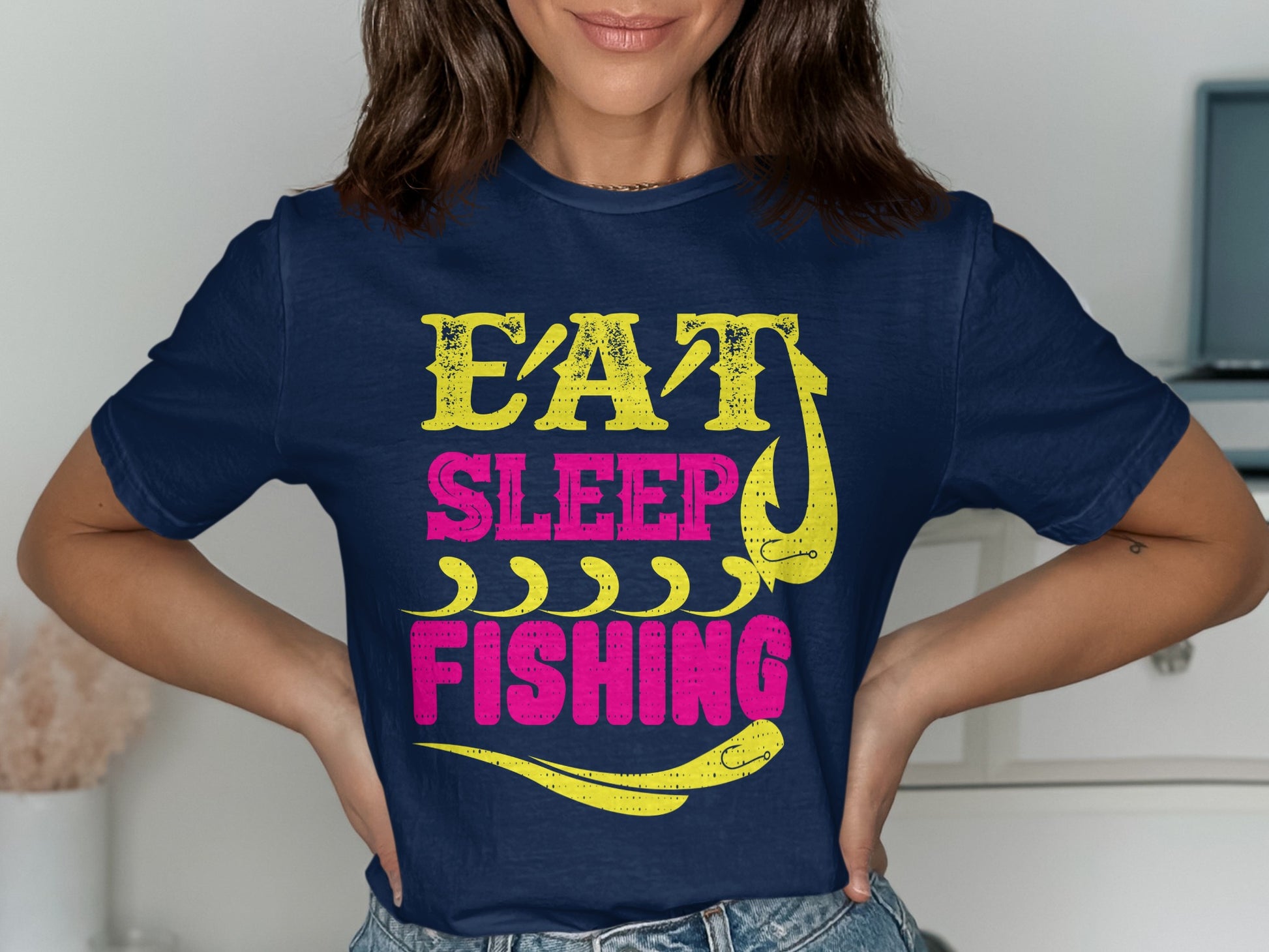 Navy t-shirt with yellow and pink "Eat Sleep Fishing" text and fish hook graphic.