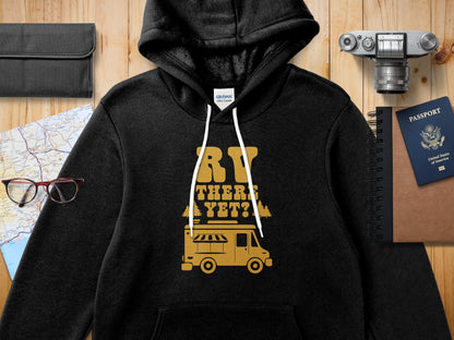 Black hoodie with "RV THERE YET?" text and a vintage camper graphic.