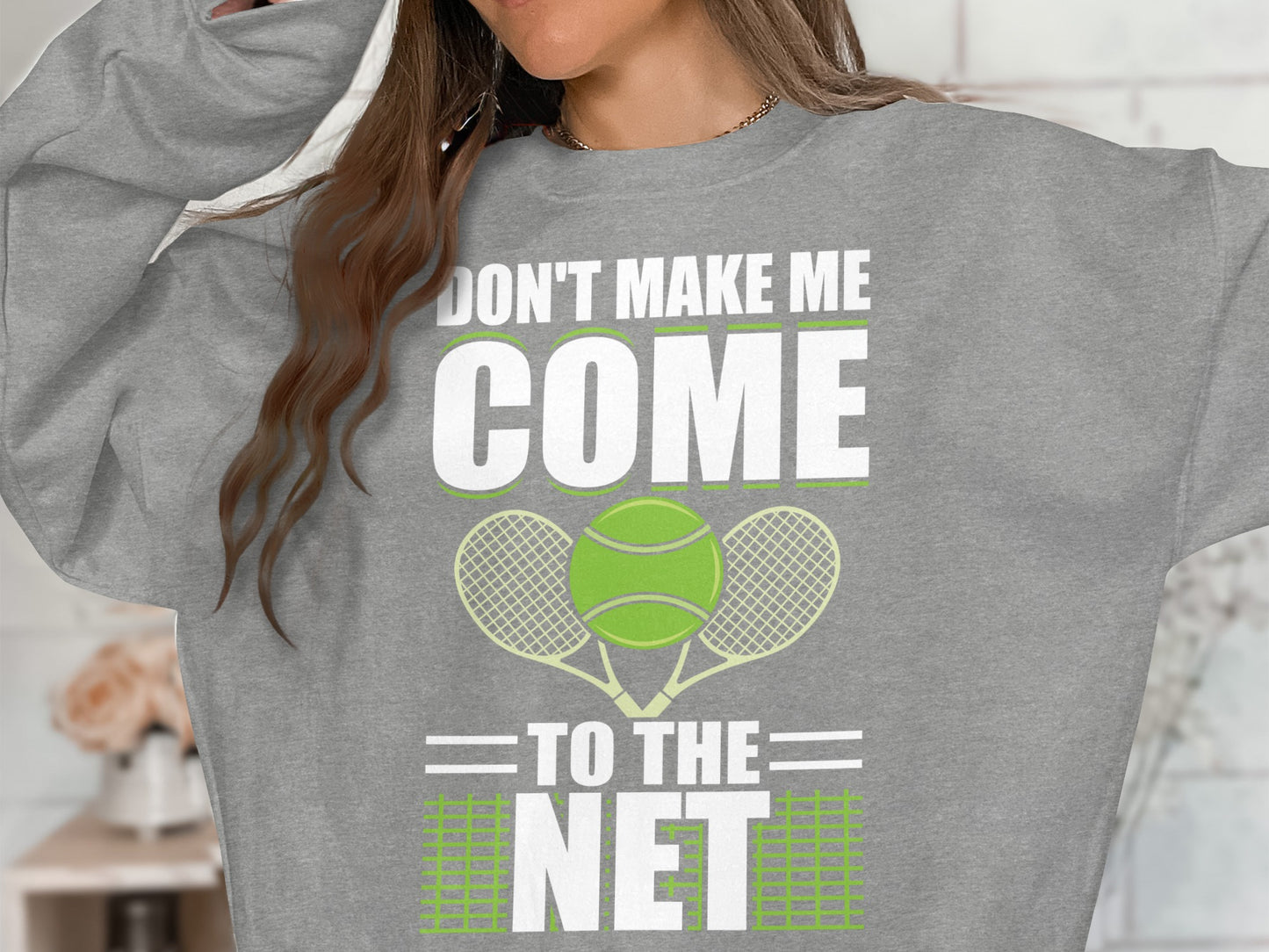 Gray sweatshirt with "DON'T MAKE ME COME TO THE NET" and tennis rackets/ball.