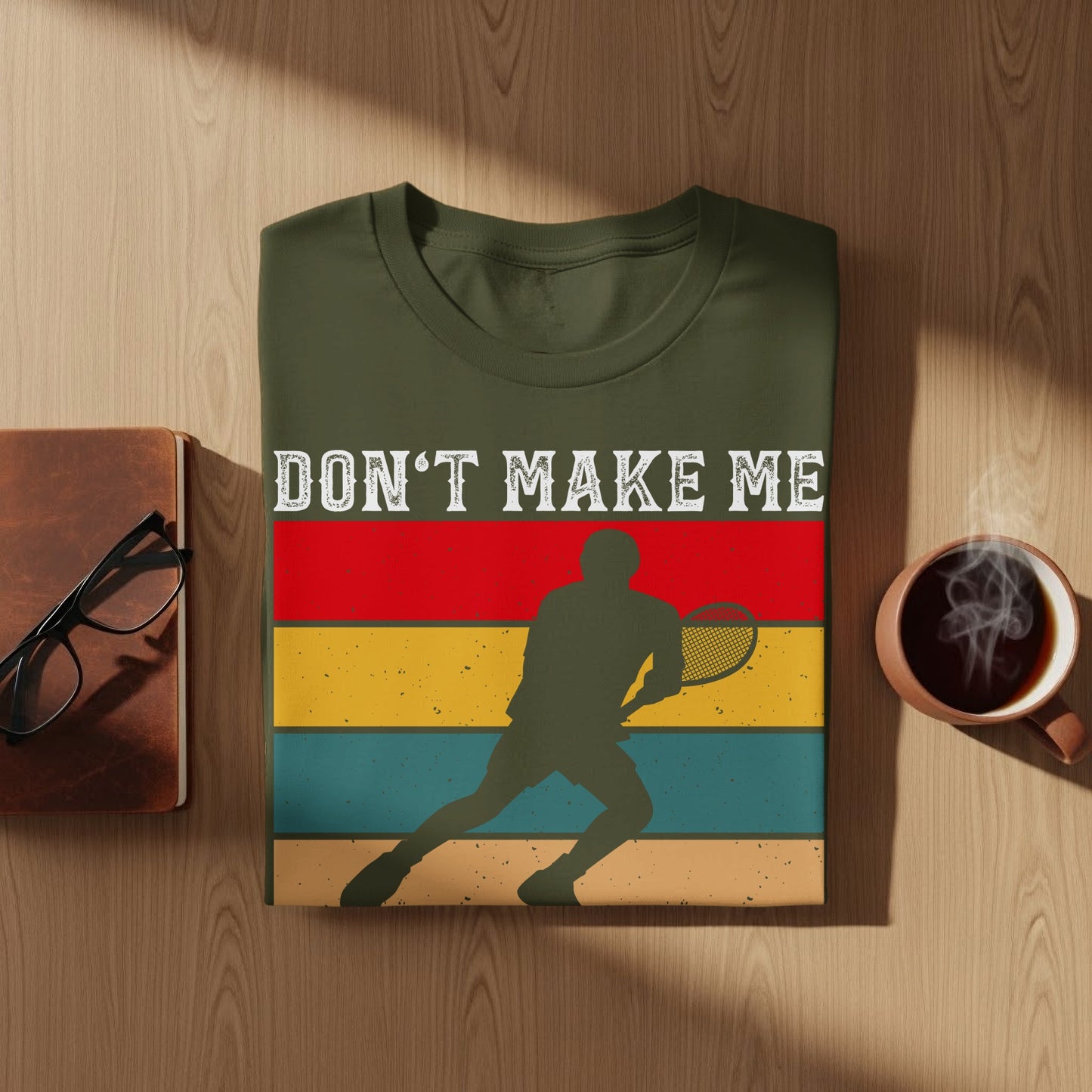 Green t-shirt with "Don't Make Me" text and tennis player silhouette.