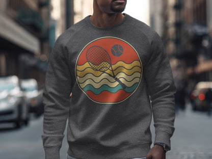 Graphic sweatshirt with a retro tennis scene featuring a racket, ball, and wavy lines.